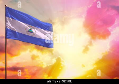 Flatternde Nicaragua Flagge in der linken oberen Ecke Mockup mit dem Ort für Ihre Informationen über schöne bunte Sonnenuntergang oder Sonnenaufgang Hintergrund. Stockfoto