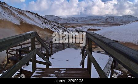 Holzpfad mit Geländer, der durch das geothermische Gebiet Seltún führt, Teil des vulkanischen Systems Krýsuvík, mit dampfenden heißen Quellen, Fumarolen. Stockfoto