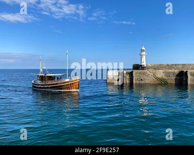 Ein Boot mit Reiseleiter kehrt zum Hafen von Mevagissey in Cornwall zurück. Stockfoto