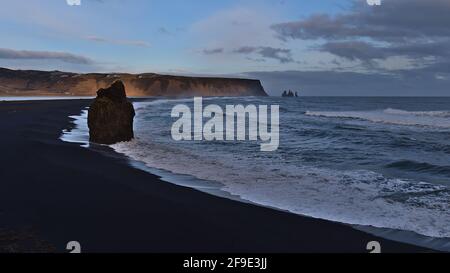 Schöner Blick über den schwarzen Vulkanstrand Reynisfjara in der Nähe der Ringstraße an der Südküste Islands mit der berühmten Felsformation Arnardrangur. Stockfoto