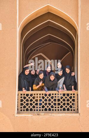 Eine Gruppe von Mädchen aus einer örtlichen Schule, die von einer Terrasse aus schauen, Bagh-e Dowlat Abad Gardens, Yazd, Iran. Stockfoto