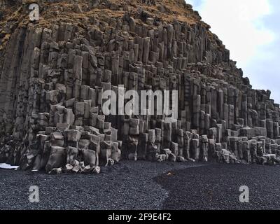 Blick auf basaltische Felsformationen am berühmten Strand Reynisfjara mit schwarzen Kieselsteinen an der Südküste Islands im Winter. Stockfoto