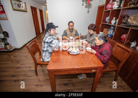 (210418) -- CHONGQING, 18. April 2021 (Xinhua) -- Ouyang Qinyun (L) ialed mit ihrer Familie zu Hause im Yubei Bezirk im südwestlichen Bezirk Chongqing, 15. April 2021. Ein Modedesigner, der zum Koch in Chongqing wurde, hat eine atemberaubende Chemie zwischen Kunst und gedämpftem Brötchen geschaffen. Ouyang Qinyun, 40, ist ein berühmter chinesischer Social-Media-Koch, der sich auf gedämpftes Brötchen oder Mantou auf Chinesisch spezialisiert hat. In der Regel mit Allzweckmehl, Hefe und Wasser hergestellt, ist Mantou ein Grundnahrungsmittel in China, vor allem im Norden. „Ich habe gelernt, dass Dampfbrötchen in verschiedenen Formen hergestellt werden können. Das wirklich ich Stockfoto