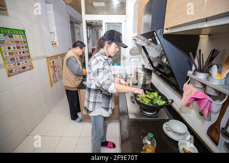 (210418) -- CHONGQING, 18. April 2021 (Xinhua) -- Ouyang Qinyun und ihr Vater kochen am 15. April 2021 zu Hause im Bezirk Yubei der südwestlichen chinesischen Gemeinde Chongqing. Ein Modedesigner, der zum Koch in Chongqing wurde, hat eine atemberaubende Chemie zwischen Kunst und gedämpftem Brötchen geschaffen. Ouyang Qinyun, 40, ist ein berühmter chinesischer Social-Media-Koch, der sich auf gedämpftes Brötchen oder Mantou auf Chinesisch spezialisiert hat. In der Regel mit Allzweckmehl, Hefe und Wasser hergestellt, ist Mantou ein Grundnahrungsmittel in China, vor allem im Norden. „Ich habe gelernt, dass Dampfbrötchen in verschiedenen Formen hergestellt werden können. Das wirklich Stockfoto