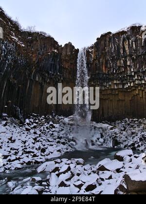 Schöner Blick auf den beliebten Wasserfall Svartifoss, umgeben von farbenfrohen vulkanischen Basaltsäulen im Skaftafell-Nationalpark im Süden Islands. Stockfoto