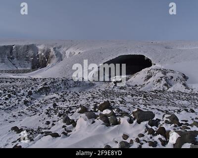 Blick auf den Eingang der Sapphire-Eishöhle, gelegen im Breiðamerkurjökull-Gletscher, Vatnajökull-Nationalpark, Südisland, mit rauer Landschaft. Stockfoto