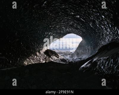 Eingang der großen Sapphire-Eishöhle, gelegen im Breiðamerkurjökull-Gletscher, Vatnajökull-Nationalpark, Island, von innen gesehen mit Eiszapfen. Stockfoto