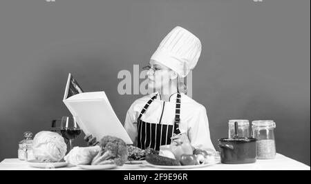 Anständige Ernährung ist die beste Diät. Kochen Konzept. Arbeiten in einer modernen Küche. Frau Koch lesen Kochbuch. Kann zum Kochen verwendet werden. Essensstudio im Restaurant Stockfoto