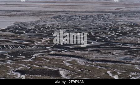 Luftaufnahme der spärlichen Landschaft von Öræfasveit (isländisch für Ödland, auch Öræfi) mit weißem und schwarzem Muster aus Schnee und Felsen und Ringstraße. Stockfoto