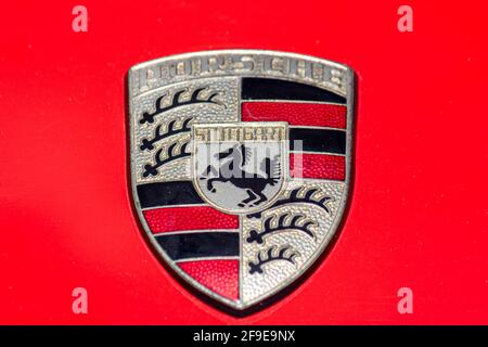 Original Porsche Wappen isoliert auf rotem Hintergrund (Motorhaube) Stockfoto