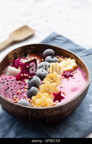 Von oben der Power-Schüssel voll von leckeren Smoothie in der Nähe Reife Bananen- und Drachenfrucht-Scheiben mit Heidelbeeren zum Frühstück Stockfoto