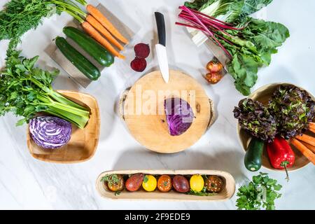 Draufsicht auf Schneidebrett mit Messer und Rotkohl Zwischen ganzen und geschnittenen Gemüse Stockfoto