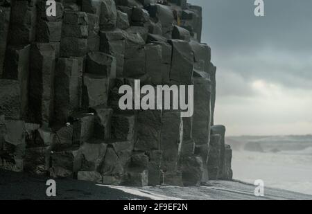 Basalt Felsformationen Troll Zehen am schwarzen Strand. bei Sturm Reynisdrangar, Vik, Island Stockfoto