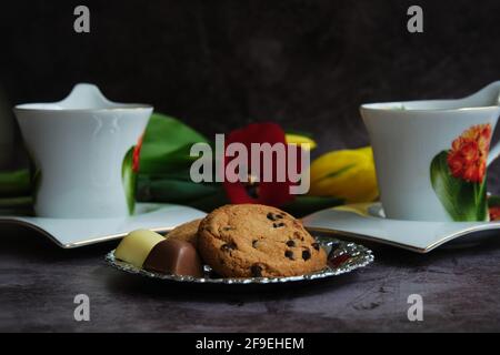 Zwei weiße Tassen Tee und gelbe und rote Tulpen Stockfoto