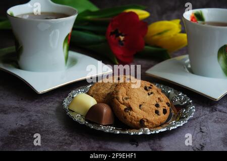 Zwei weiße Tassen Tee und gelbe und rote Tulpen Stockfoto