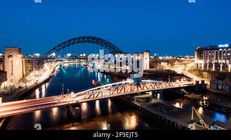 Newcastle upon Tyne Großbritannien: 30. März 2021: Newcastle Gateshead Quayside bei Nacht, mit der Tyne Bridge und der Skyline der Stadt, lange Belichtung während der blauen Stunde Stockfoto