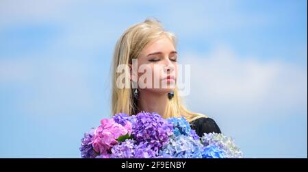 Mädchen zart blonde halten Hortensia Blumen Blumenstrauß. Allergiefreies Leben. Stoppen Sie die Blütezeit der Allergie. Genießen Sie den Frühling ohne Allergie. Frühjahrsblüte Stockfoto