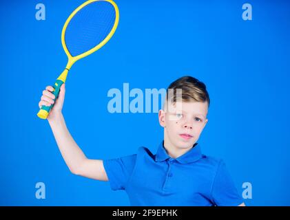 Tennisspielen üben. Kerl mit Schläger genießen Spiel. Zukünftiger Champion. Träumen von Sportkarriere. Athlet Kinder Tennisschläger auf blauem Hintergrund Stockfoto