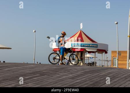 05-04-2021. tel aviv-israel. Ein Blick auf einen Radfahrer auf der Reitpromenade, im Hintergrund des berühmten Karussells Stockfoto