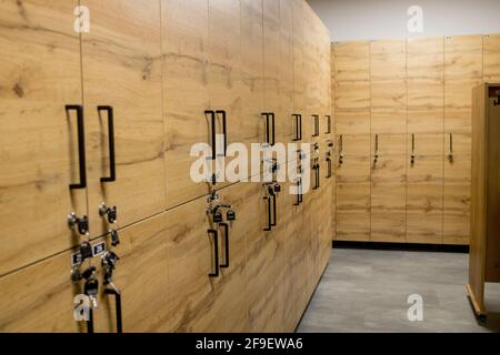 Holzschrankboxen mit Metallschlössern. Klassische Holz Umkleideraum und eine Bank. Stockfoto