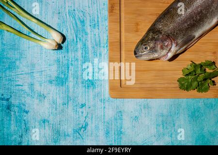 Zwei frische Fische auf Küchenbrett mit blauem Hintergrund Stockfoto