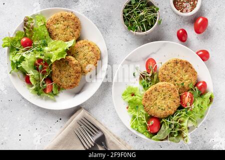 Vegane Burger mit Quinoa in Tellern mit Salat Stockfoto