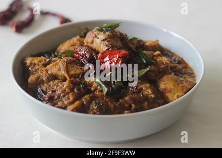 Kerala-Chicken-Kerray in Kokosöl mit hausgemachtem Masala-Pulver. Aufgenommen auf weißem Hintergrund. Stockfoto