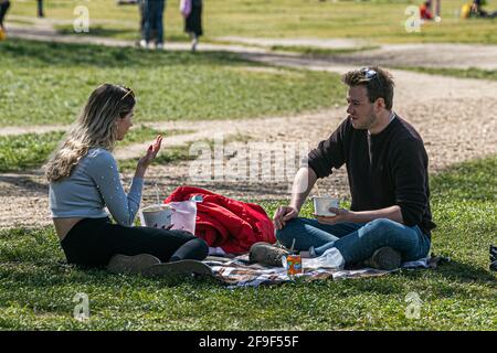 WIMBLEDON LONDON, GROSSBRITANNIEN. 18. April 2021. Menschen, die am ersten Wochenende der Lockerung der Covid-19-Einschränkungen am Wimbledon Common die Sonne und das warme Wetter genießen, mit einer Mini-Hitzewelle, die London und Teile Großbritanniens diese Woche mit höheren Temperaturen von bis zu 22 Grad erreichen wird. Credit amer Ghazzal/Alamy Live News Stockfoto