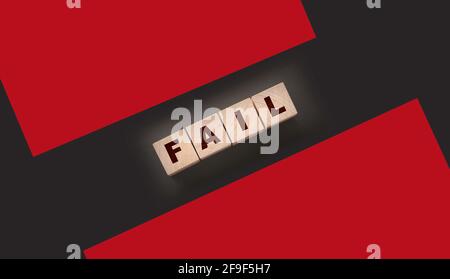 FAIL Word-Text in Holzwürfelblöcken auf schwarzem Hintergrund geschrieben. Krisenkonzept. Stockfoto