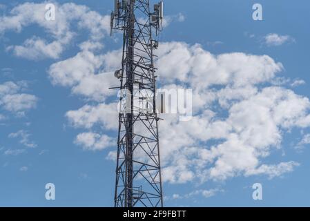 Mobilfunkdatenübertragungsturm auf blauem, natürlichem Hintergrund. Kommunikationsinfrastruktur für die Datenübertragung. Natürliche Landschaft. Metallstruktur. Stockfoto