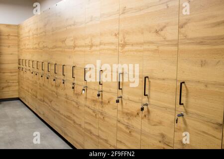 Holzschrankboxen mit Metallschlössern. Klassische Holz Umkleideraum und eine Bank. Stockfoto