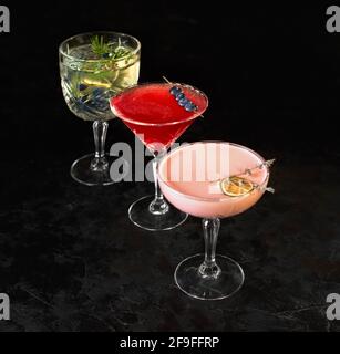 Drei alkoholische Cocktails stehen auf schwarzem Hintergrund. Eiscocktail mit Zitrone und Kräutern. Platz für Text. Foto für das Menü. Stockfoto