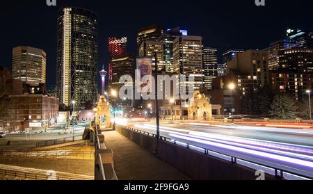 Calgary Alberta Kanada, April 7 2021: Langzeitaufnahme über der Center Street Bridge von Wahrzeichen und Gebäuden der Innenstadt bei Nacht in einem Kanadier Stockfoto