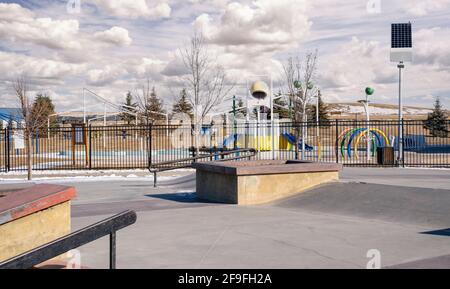 Ein leerer Skatepark und ein Outdoor-Planschpark mit Sonnenkollektoren zum Aufladen von LED-Straßenlaternen in der Stadtgemeinde Airdrie Alberta Canada. Stockfoto