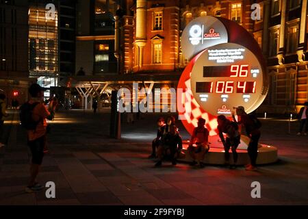 Hachioji, Japan. April 2021. Fußgänger Nehmen Sie am Sonntag, den 18. April 2021, am Bahnhof Tokio in Tokio, Japan, ein Foto mit der großen Countdown-Uhr für die Olympischen Spiele 2020 in Tokio auf. Foto von Keizo Mori/UPI Credit: UPI/Alamy Live News Stockfoto