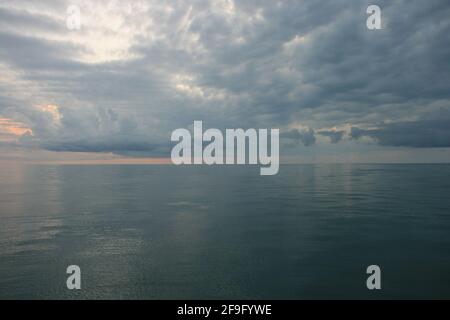 Tropische Wolken spiegeln sich in einem glasigen Ozean Stockfoto