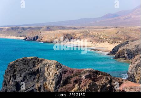 Playa Blanca, Lanzarote, Kanarische Inseln, Spanien. Blick entlang der Küste von der Klippe über Playa del Papagayo. Stockfoto