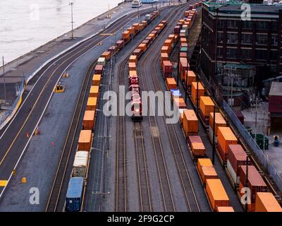 Blick auf einen Güterzug mit einer roten Lokomotive Zwischen zwei anderen Güterzügen Stockfoto