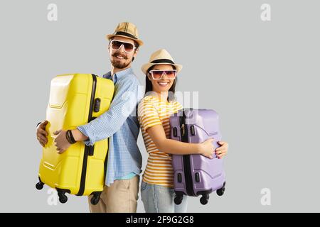 Glücklich lächelndes Paar Tourist im Sommer Hut und Sonnenbrille halten Gepäcktasche Stockfoto