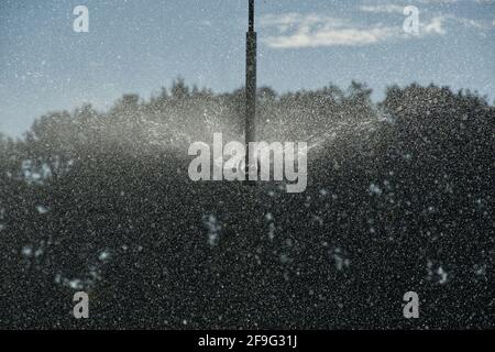 Wasserspritzung von einem Sprinkler auf einem Pivot-Feld-Bewässerungssystem des landwirtschaftlichen Zentrums. Stockfoto