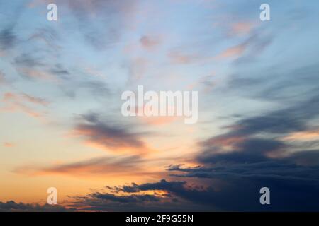 Sonnenuntergang am bunten Himmel, Wolken im rosa und orangefarbenen Sonnenlicht. Malerische Landschaft als Hintergrund mit sanften Farben Stockfoto