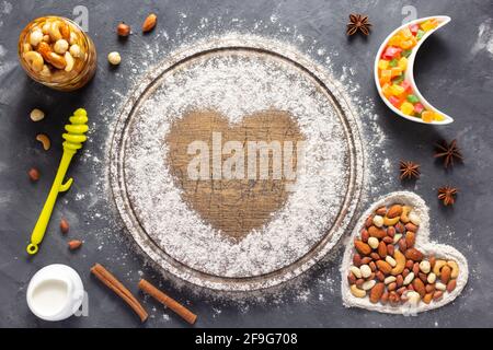 Weizenmehl an Holzbrotbrett mit Backzutaten für selbstgebackenes Backen auf dem Tisch. Essen Rezept Cookies Konzept auf Stein Hintergrund textu Stockfoto