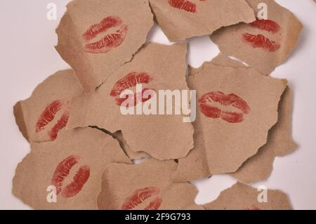 aufdruck von Frauenlippen in rotem Lippenstift mit Inschrift Love You auf eingewickeltem Papier, viele Küsse Stockfoto