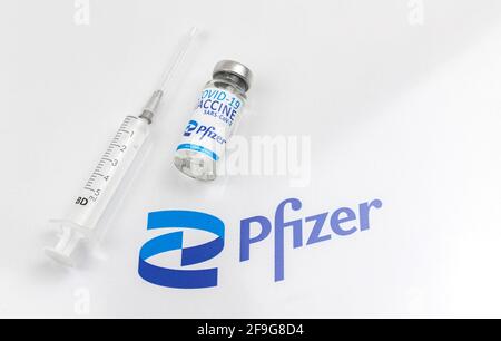 Charkov, Ukraine - 18. April 2021: Pfizer COVID-19-Impfstoff entwickelt von BioNTech, Impfschutz-Hintergrundbild mit Firmenlogo Stockfoto