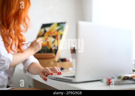 Nahaufnahme einer rothaarigen Malerin, die ein Meisterwerk mit Öl geschaffen hat Farben Stockfoto