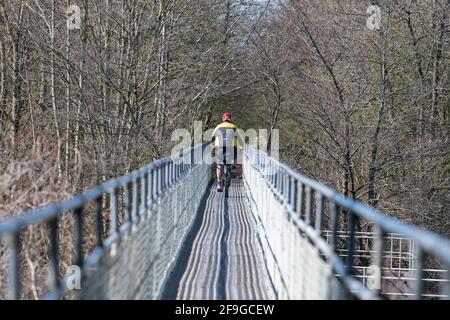 Radler auf der Radroute 7, die auf dem Metallrohrbrückenweg das Wasser von Endrick überquert, Croftamie, Stirling, Schottland, Großbritannien Stockfoto