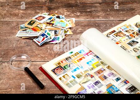 Briefmarkenalbum voll gebrauchter britischer Briefmarken Eine rustikale Holztischplatte Stockfoto