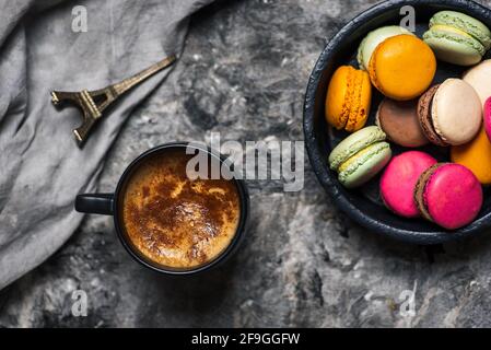 Macaron oder Makronen süße Plätzchen Desserts und eine Tasse Kaffee auf einem Holztisch, Tischansicht Stockfoto