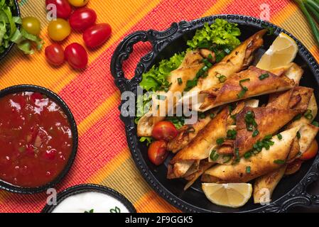 Hausgemachte kleine Tacos mit Huhn, Dip-Saucen und Lebensmittelzutaten genannt Taquitos Stockfoto