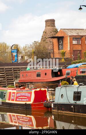 Narrowboats auf dem Trent und Mersey Kanal bei Longport Boot Yard Stoke auf Trent Staffordshire mit einem alten Flaschenofen Im Hintergrund Stockfoto